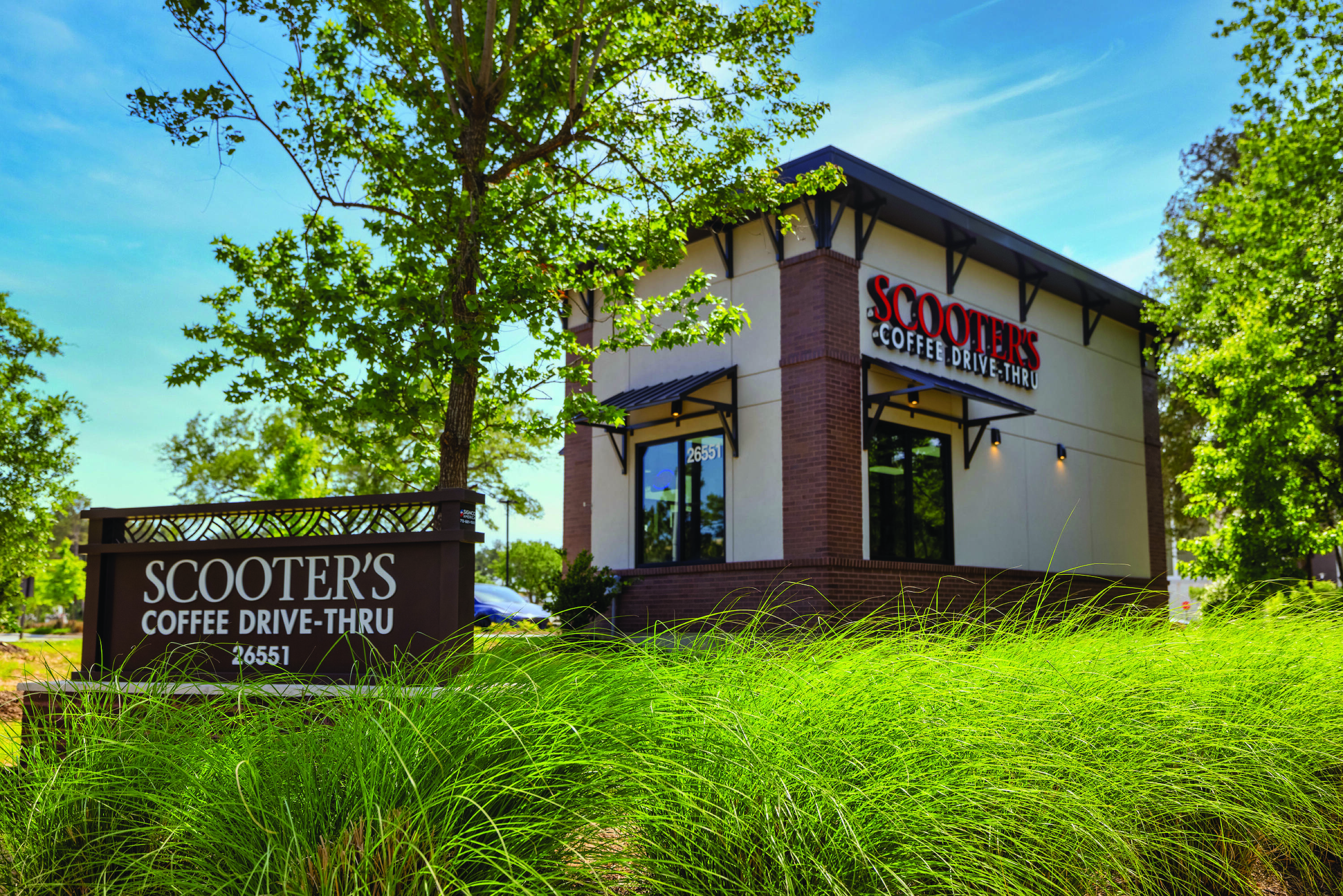 Exterior view of a fully leased retail property at Creekside Park Village Center with a drive-thru and ample parking.